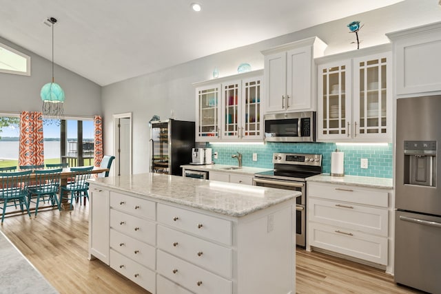 209 Anchor Ranch Rd, Trinidad, TX 75163 - kitchen with stainless steel appliances, vaulted ceiling, tasteful backsplash, a kitchen island, and light wood-style flooring