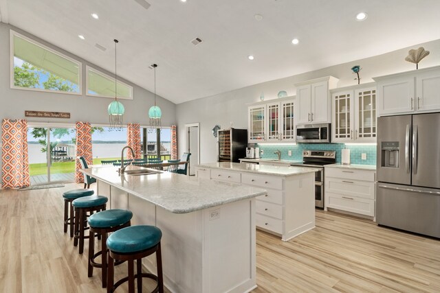 209 Anchor Ranch Rd, Trinidad, TX 75163 - kitchen featuring appliances with stainless steel finishes, a large island with sink, light wood-style flooring, a sink, and backsplash