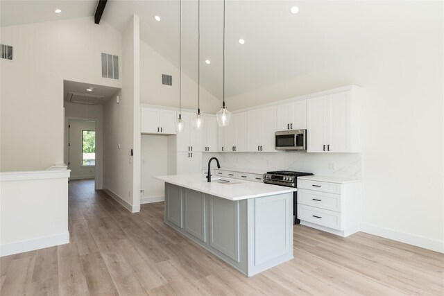 6137 Pacific Forest Dr, Houston, TX 77346 - kitchen with appliances with stainless steel finishes, light wood-type flooring, beamed ceiling, decorative backsplash, and light countertops