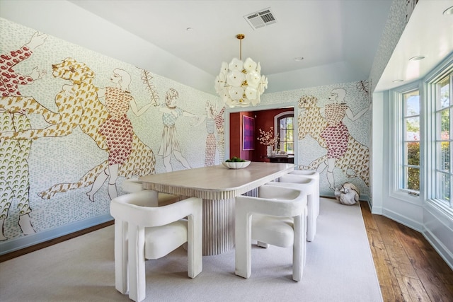 dining space featuring hardwood / wood-style flooring, a chandelier, and baseboards