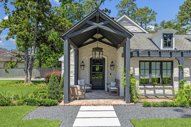 doorway to property with stone siding and a porch