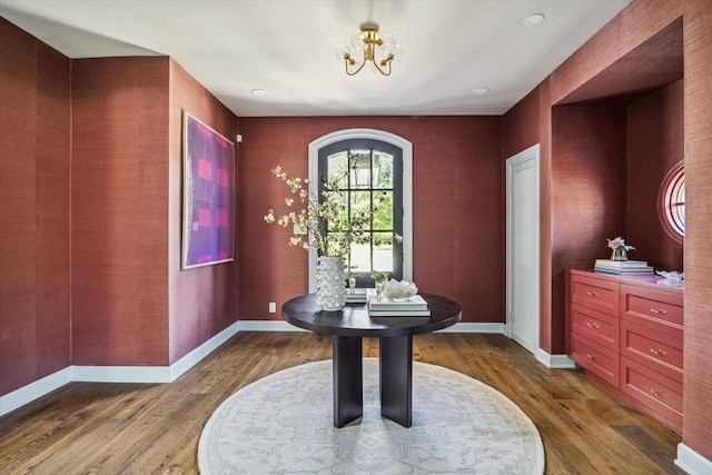 entrance foyer with a chandelier, dark wood-style flooring, and baseboards