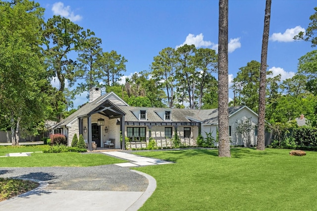 view of front of house with a front lawn, a chimney, and stone siding