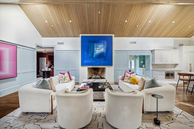 living room with a decorative wall, wooden ceiling, a high ceiling, light wood-style flooring, and a fireplace