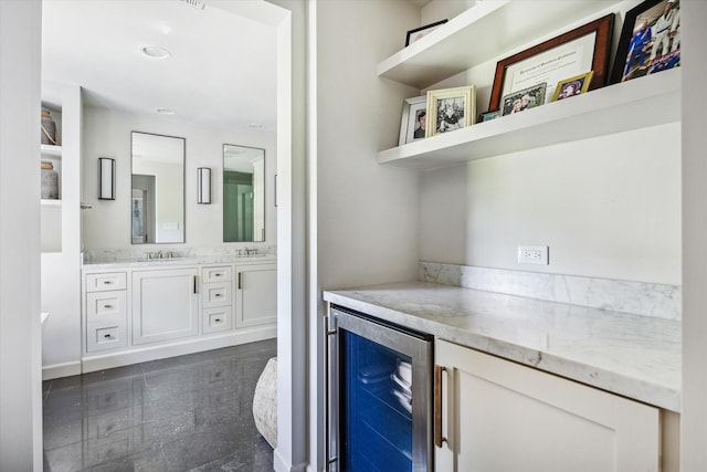 indoor dry bar with wine cooler, granite floors, and baseboards
