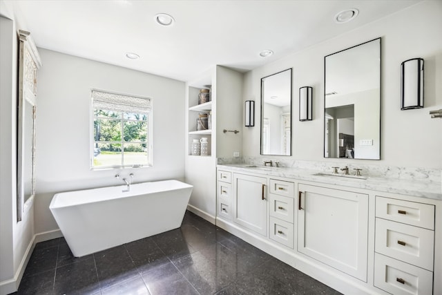 full bath with baseboards, double vanity, recessed lighting, and a freestanding bath