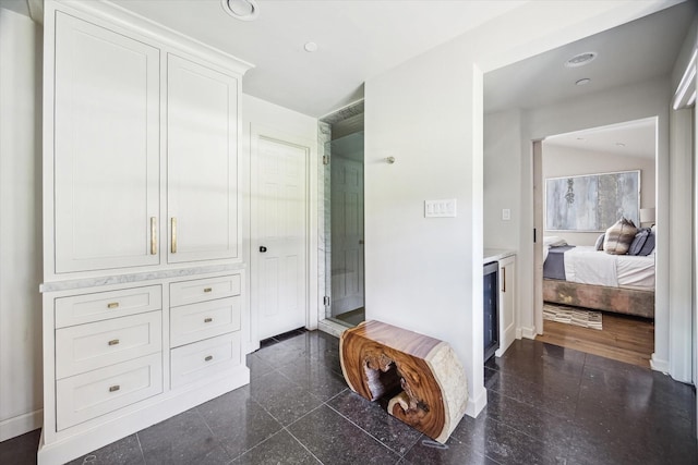 hallway featuring baseboards, granite tiled floors, and recessed lighting