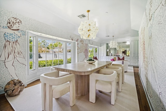 dining area featuring a chandelier, light wood-style floors, wallpapered walls, and baseboards