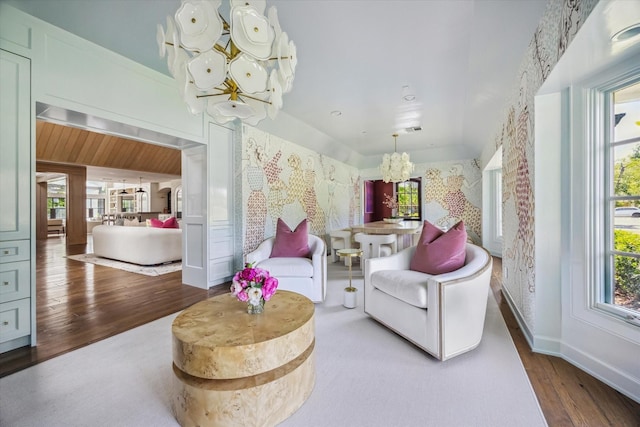 sitting room featuring a chandelier, wood finished floors, and baseboards