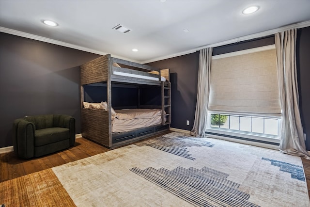 bedroom with wood finished floors, recessed lighting, ornamental molding, and baseboards