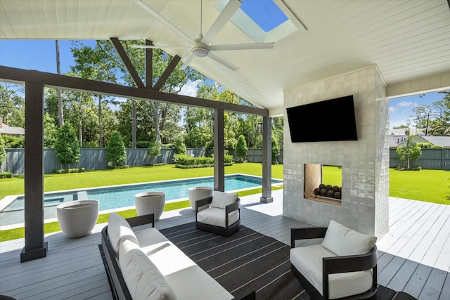 wooden terrace featuring ceiling fan and an outdoor living space with a fireplace