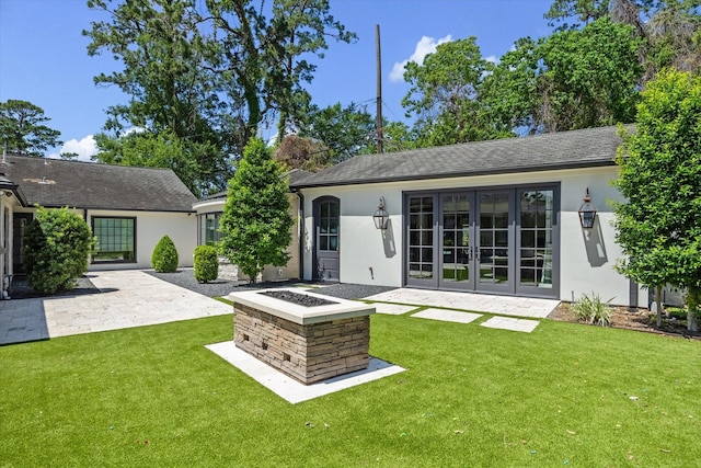 back of property featuring french doors, stucco siding, a lawn, and a patio
