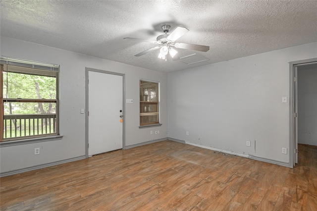 2240 Easley Cir, Huntsville, TX 77320 - empty room with wood finished floors, a textured ceiling, a ceiling fan, and baseboards