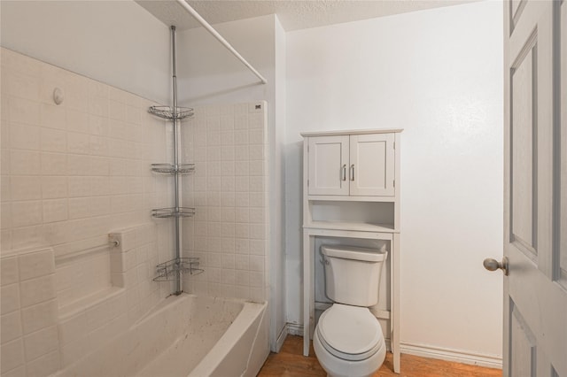 2240 Easley Cir, Huntsville, TX 77320 - bathroom with toilet, shower / washtub combination, wood finished floors, and a textured ceiling