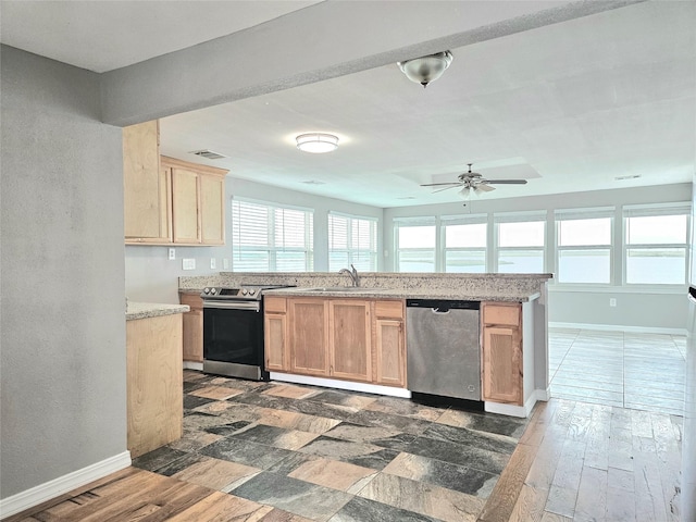 4606 Warren Way, Hitchcock, TX 77563 - kitchen with appliances with stainless steel finishes, a sink, light brown cabinetry, a ceiling fan, and baseboards