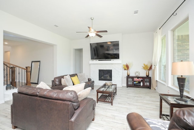 10134 Blythe St, Rosharon, TX 77583 - living area featuring stairs, light wood-style floors, a premium fireplace, ceiling fan, and baseboards