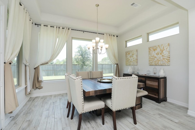 10134 Blythe St, Rosharon, TX 77583 - dining space featuring a chandelier, a tray ceiling, light wood-style floors, and baseboards