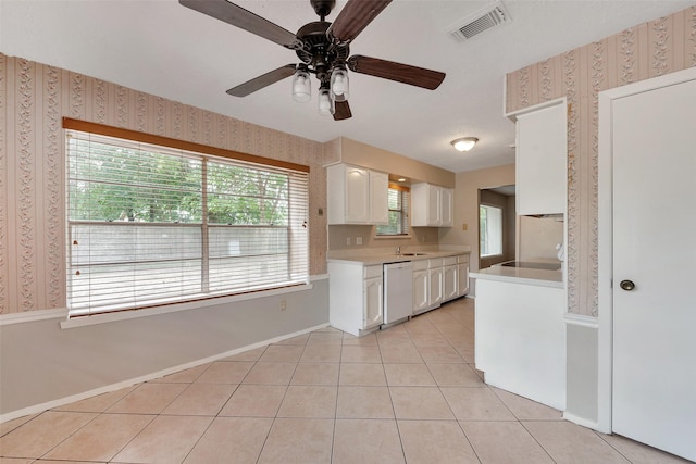 9507 Rannock Way, Spring, TX 77379 - kitchen with wallpapered walls, light countertops, white cabinetry, white dishwasher, and baseboards