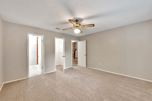 9507 Rannock Way, Spring, TX 77379 - unfurnished bedroom with carpet, baseboards, a walk in closet, ceiling fan, and a textured ceiling