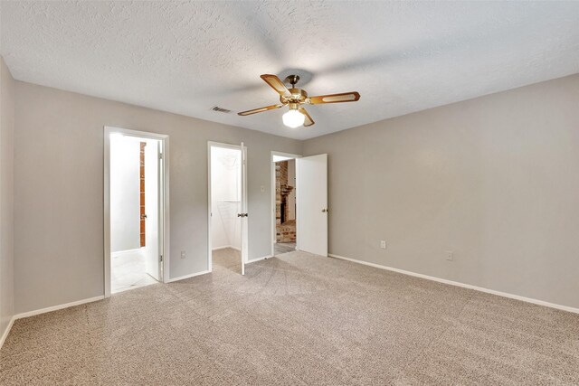 9507 Rannock Way, Spring, TX 77379 - unfurnished bedroom featuring carpet floors, baseboards, a walk in closet, a textured ceiling, and a ceiling fan