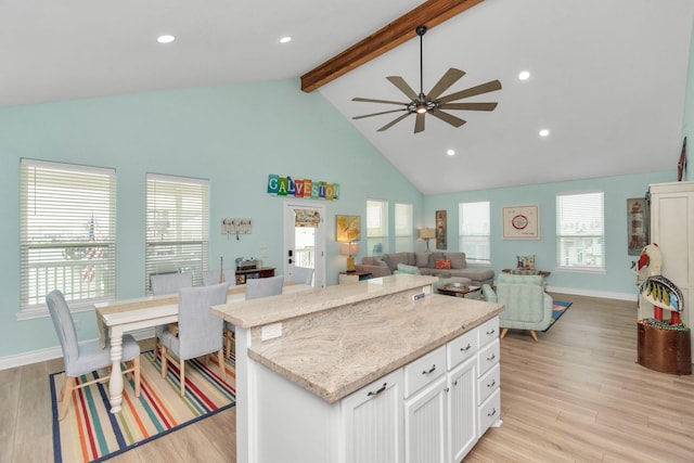 4019 Ector Dr, Galveston, TX 77554 - kitchen featuring beamed ceiling, white cabinetry, a ceiling fan, light wood-style floors, and high vaulted ceiling