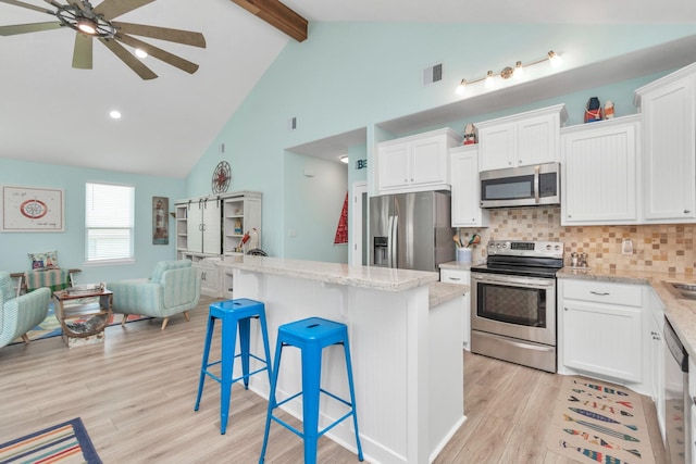 4019 Ector Dr, Galveston, TX 77554 - kitchen with appliances with stainless steel finishes, open floor plan, a ceiling fan, beamed ceiling, and light wood-type flooring