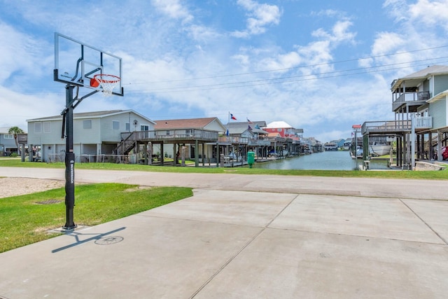 4019 Ector Dr, Galveston, TX 77554 - view of basketball court with a yard, stairway, a water view, and a residential view