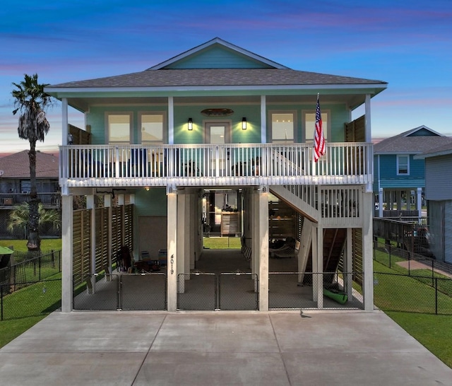 4019 Ector Dr, Galveston, TX 77554 - coastal home with a porch, a shingled roof, stairway, and concrete driveway