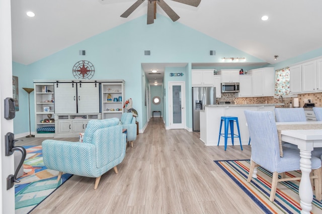 4019 Ector Dr, Galveston, TX 77554 - living room with high vaulted ceiling, light wood finished floors, ceiling fan, baseboards, and recessed lighting