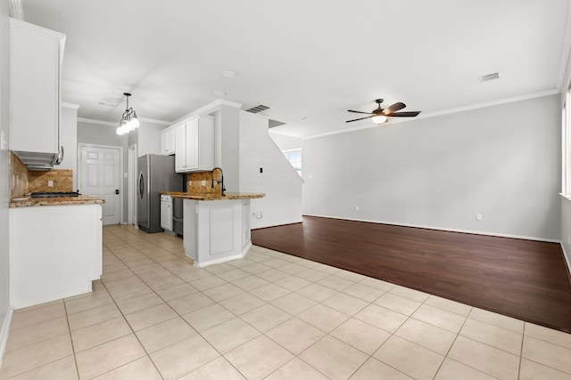 137 E Summerhaze Cir, The Woodlands, TX 77382 - kitchen with crown molding, open floor plan, freestanding refrigerator, light tile patterned floors, and ceiling fan