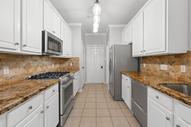 137 E Summerhaze Cir, The Woodlands, TX 77382 - kitchen featuring stainless steel appliances, ornamental molding, white cabinets, light tile patterned flooring, and stone countertops
