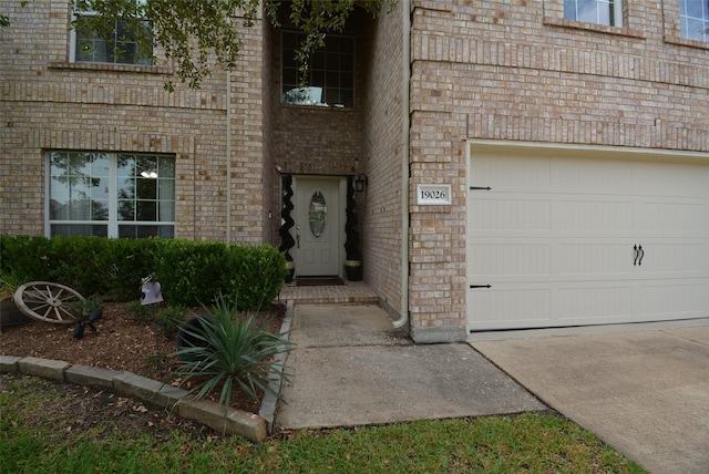 19026 Rustling Ridge Ln, Tomball, TX 77377 - view of exterior entry featuring brick siding, a garage, and concrete driveway