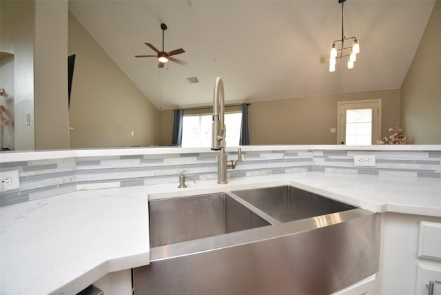 19026 Rustling Ridge Ln, Tomball, TX 77377 - kitchen with vaulted ceiling, ceiling fan, light stone countertops, white cabinetry, and decorative backsplash