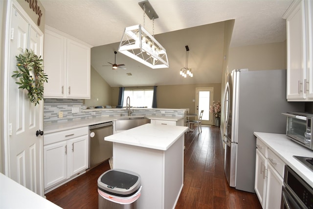 19026 Rustling Ridge Ln, Tomball, TX 77377 - kitchen with appliances with stainless steel finishes, a peninsula, white cabinets, lofted ceiling, and decorative backsplash