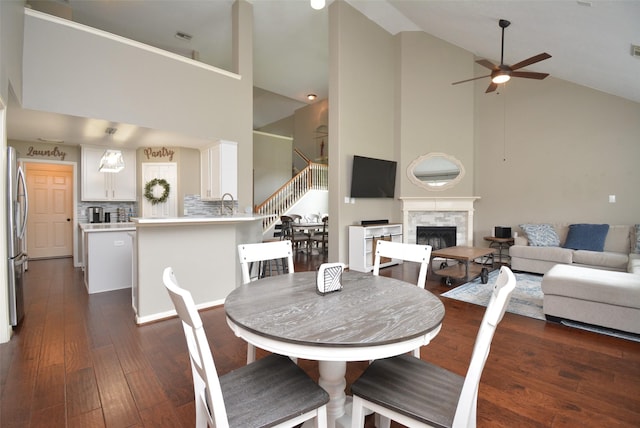 19026 Rustling Ridge Ln, Tomball, TX 77377 - dining area with high vaulted ceiling, ceiling fan, stairway, dark wood finished floors, and a stone fireplace