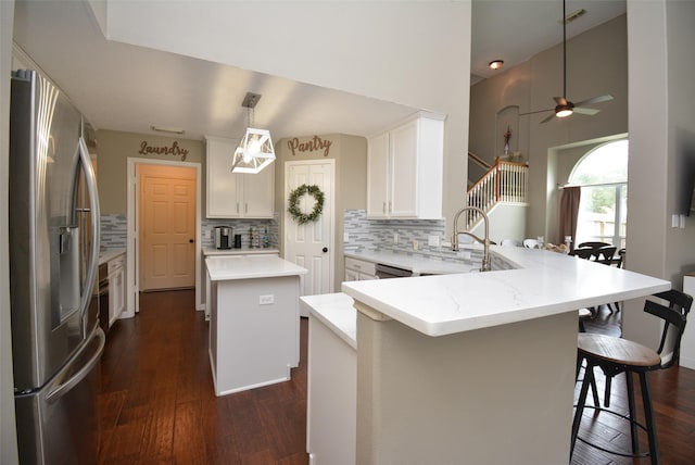 19026 Rustling Ridge Ln, Tomball, TX 77377 - kitchen with stainless steel appliances, a peninsula, tasteful backsplash, dark wood-type flooring, and a center island