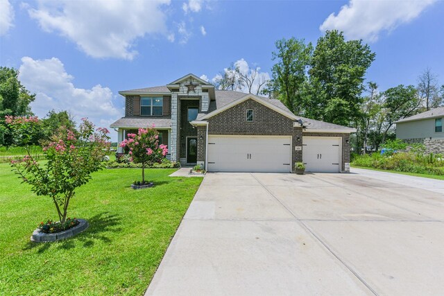 579 Rd 6618, Dayton, TX 77535 - view of front facade with an attached garage, driveway, a front yard, brick siding, and a shingled roof
