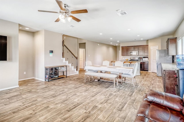 22624 Theodoli Dr, Katy, TX 77449 - living room featuring light wood-style floors, stairway, a ceiling fan, baseboards, and recessed lighting