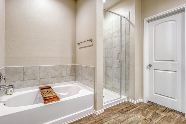22624 Theodoli Dr, Katy, TX 77449 - full bath featuring a stall shower, a bath, wood finished floors, and a textured wall