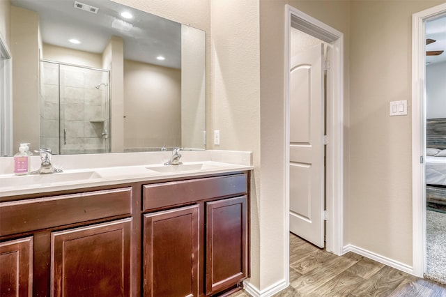 22624 Theodoli Dr, Katy, TX 77449 - full bathroom with double vanity, wood finished floors, a tile shower, and baseboards