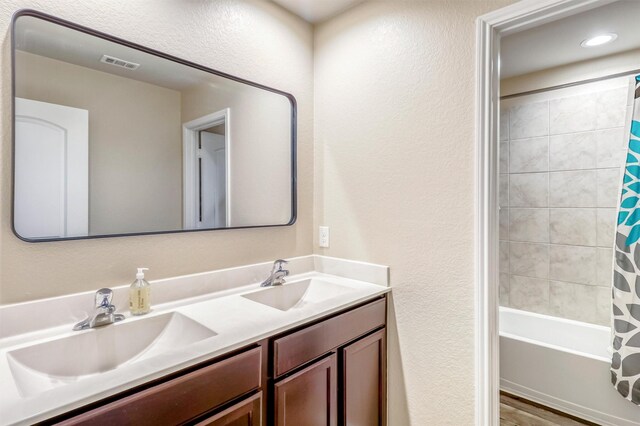 22624 Theodoli Dr, Katy, TX 77449 - full bathroom featuring double vanity, a textured wall, and shower / tub combo with curtain