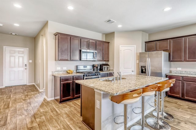 22624 Theodoli Dr, Katy, TX 77449 - kitchen featuring stainless steel appliances, a sink, light wood-style flooring, light stone countertops, and recessed lighting