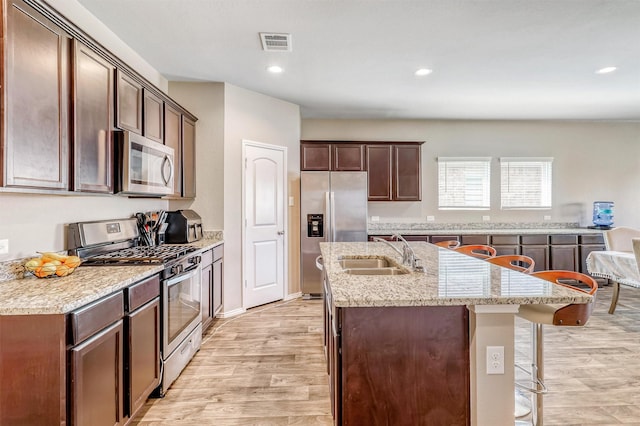 22624 Theodoli Dr, Katy, TX 77449 - kitchen with appliances with stainless steel finishes, a sink, a center island with sink, light wood-type flooring, and recessed lighting