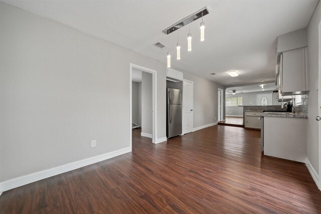 10134 Palestine St, Houston, TX 77029 - unfurnished living room featuring dark wood finished floors, baseboards, and a ceiling fan