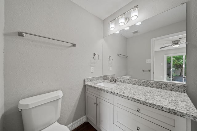 10134 Palestine St, Houston, TX 77029 - half bath with toilet, vanity, a ceiling fan, and wood finished floors