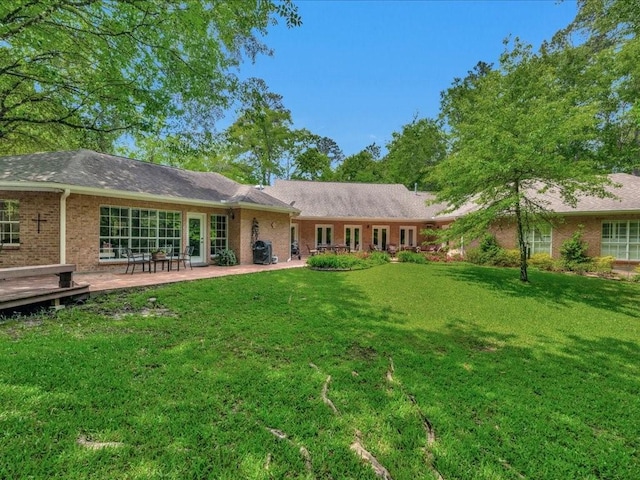 1908 Columbine Dr, Lufkin, TX 75904 - rear view of property with a yard, brick siding, and a patio area