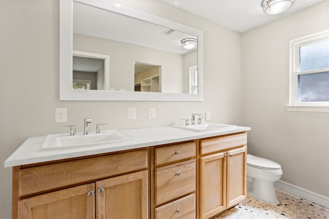 5000 Old Castle Ln, Dickinson, TX 77539 - bathroom featuring double vanity, toilet, and baseboards