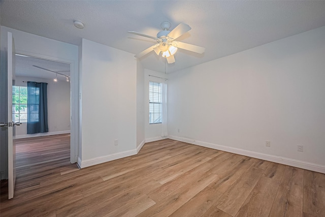 2750 Holly Hall St Unit 910, Houston, TX 77054 - empty room with wood finished floors, ceiling fan, a smoke detector, baseboards, and track lighting