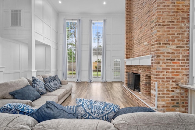5523 Theall Rd, Houston, TX 77066 - living room featuring a decorative wall, wood finished floors, a brick fireplace, recessed lighting, and crown molding