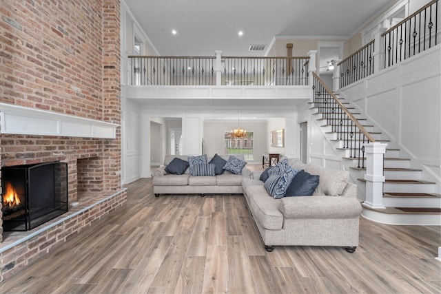 5523 Theall Rd, Houston, TX 77066 - living area featuring a fireplace, stairway, a towering ceiling, wood finished floors, and a chandelier